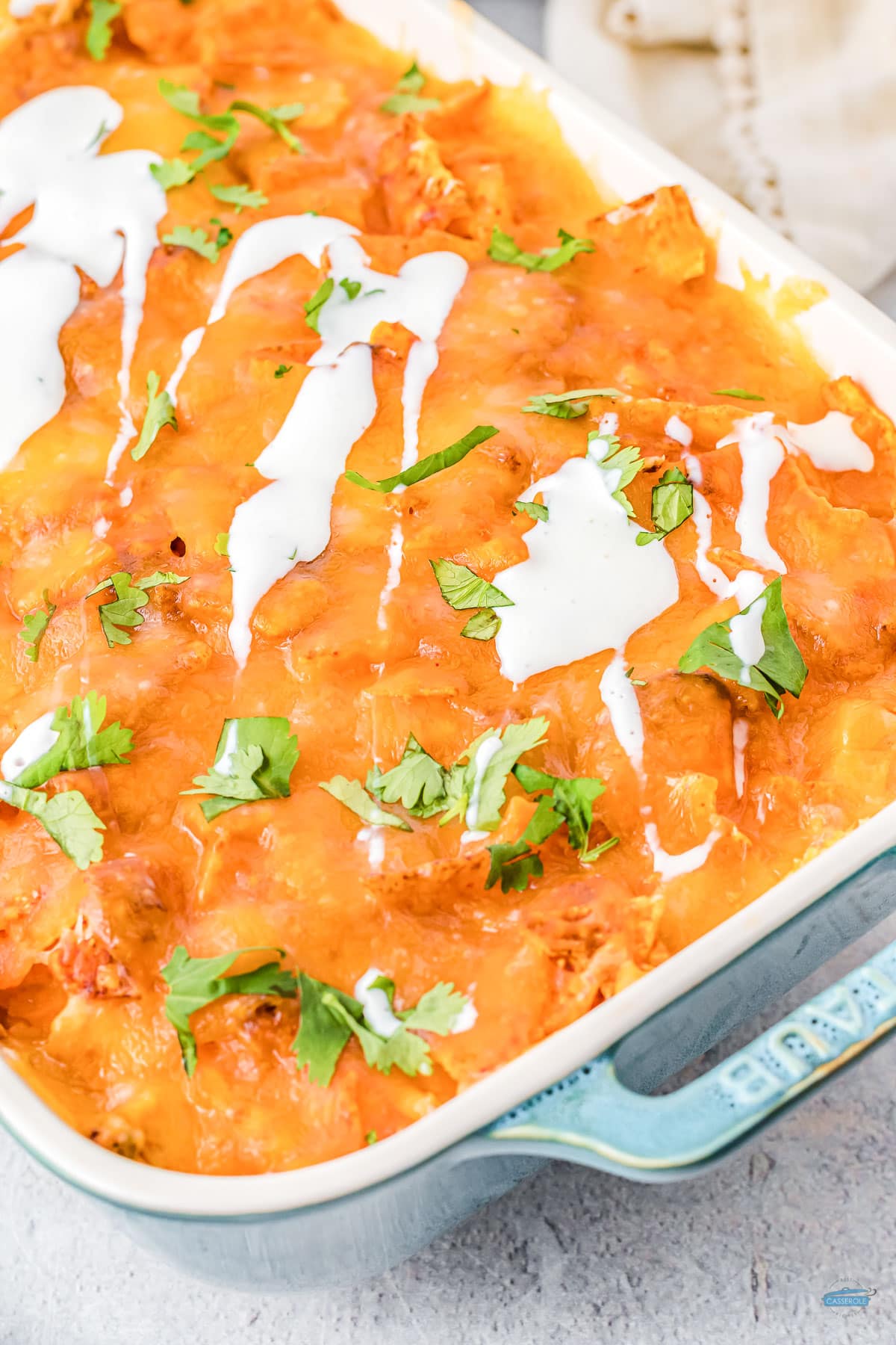 close up of mexican chicken casserole topped with sour cream