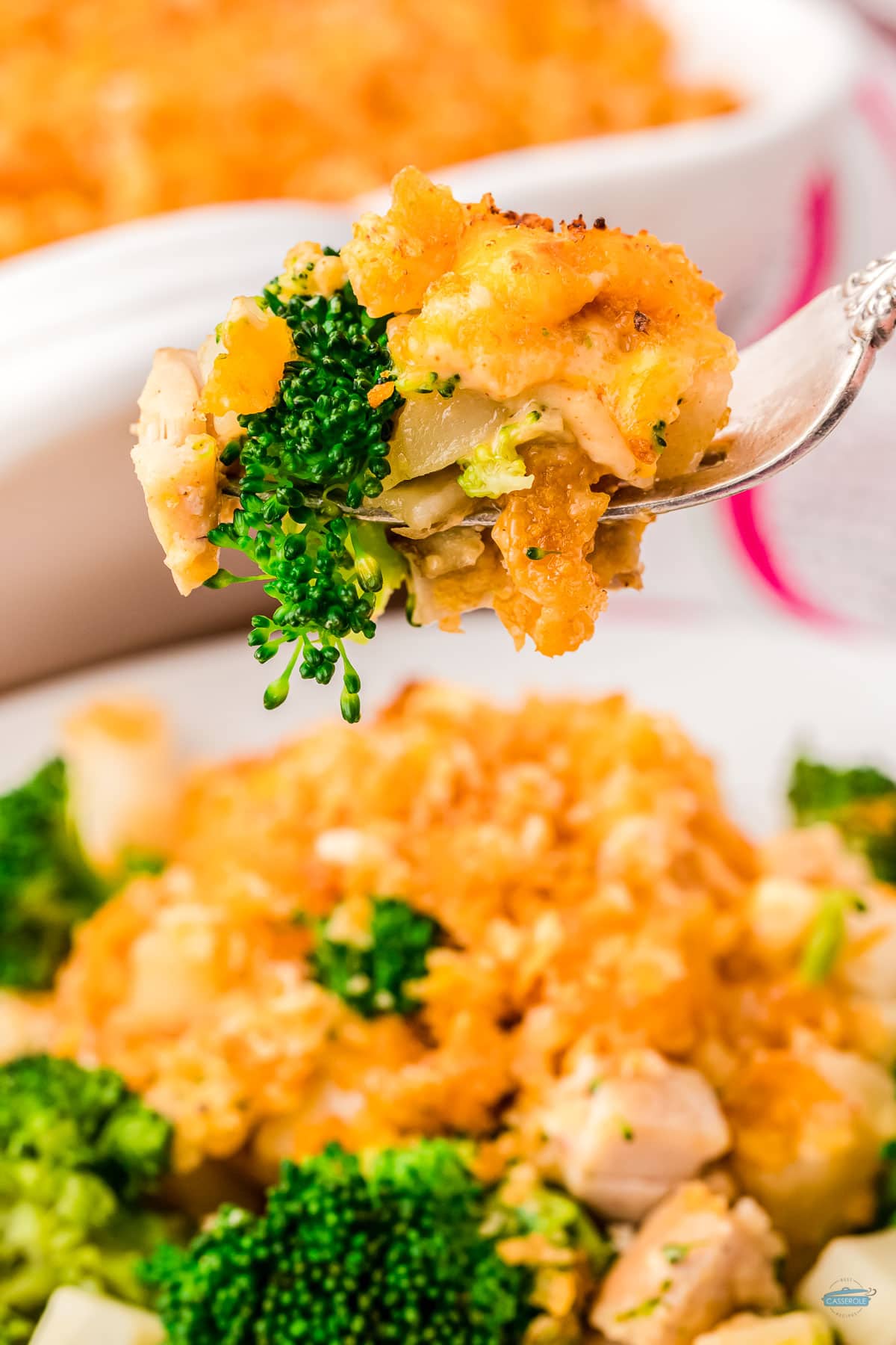 fork holding a bite of chicken broccoli potato casserole