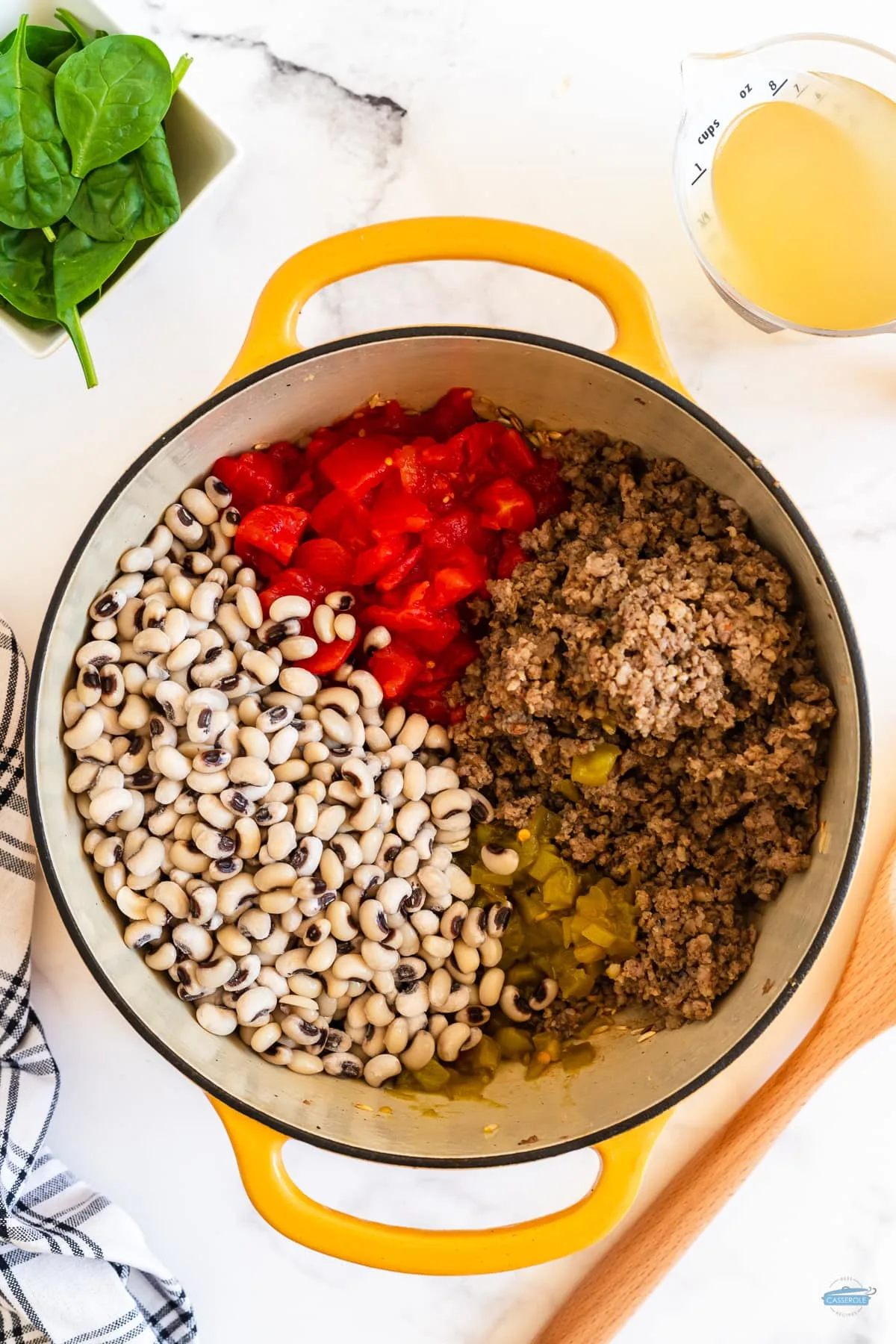 tomatoes, black eyed peas, and ground beef in a yellow pot