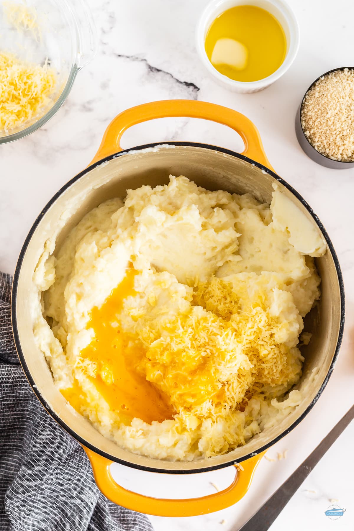 mashed potatoes in a yellow pot with shredded cheese