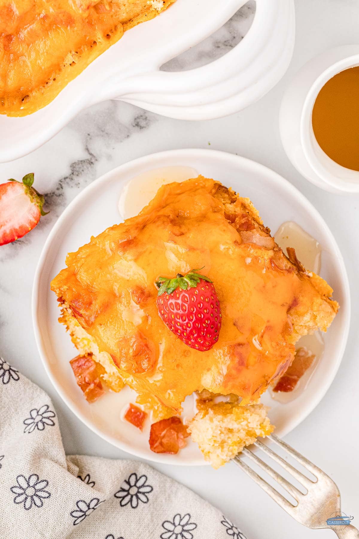 overhead picture of casserole with strawberry on top and a gold fork