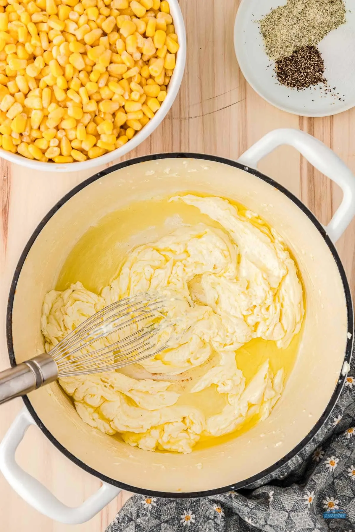 cream cheese and butter in a pot with a whisk