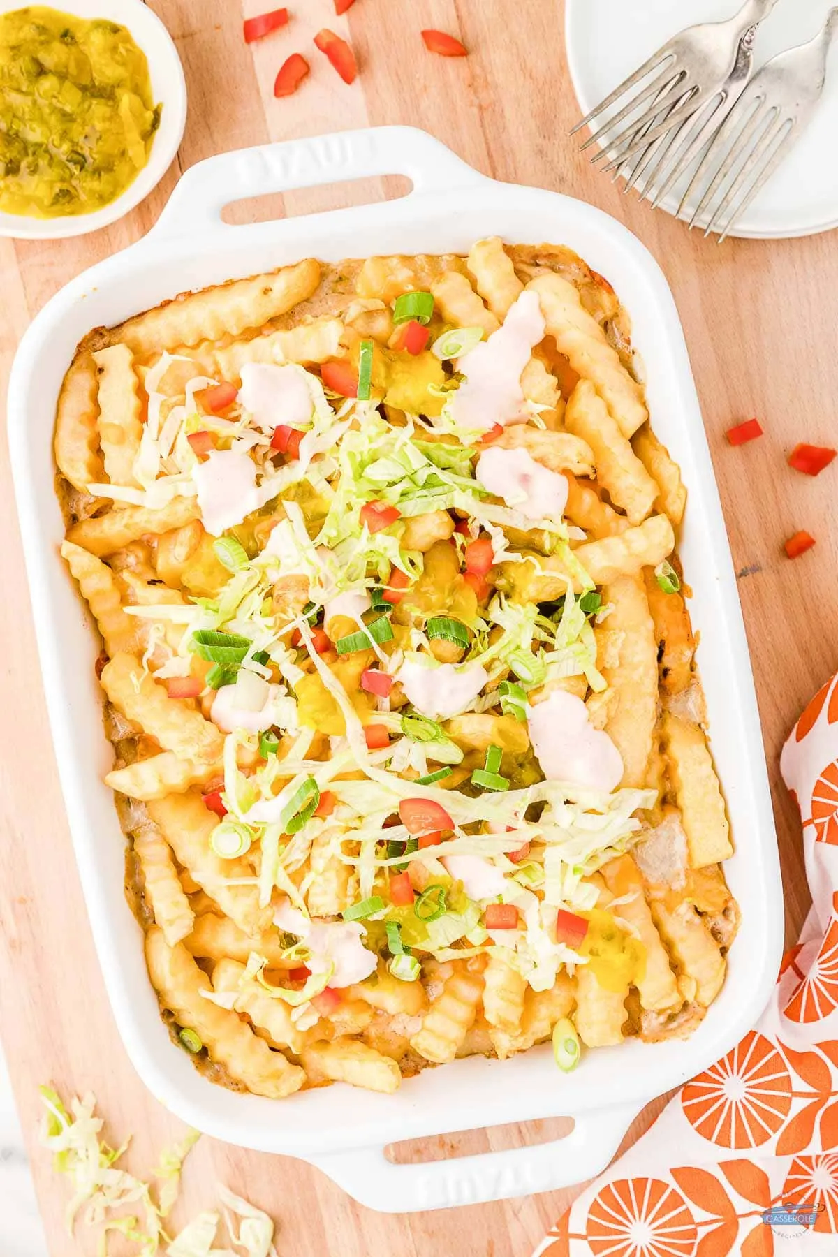 french fry casserole topped with lettuce and tomatoes