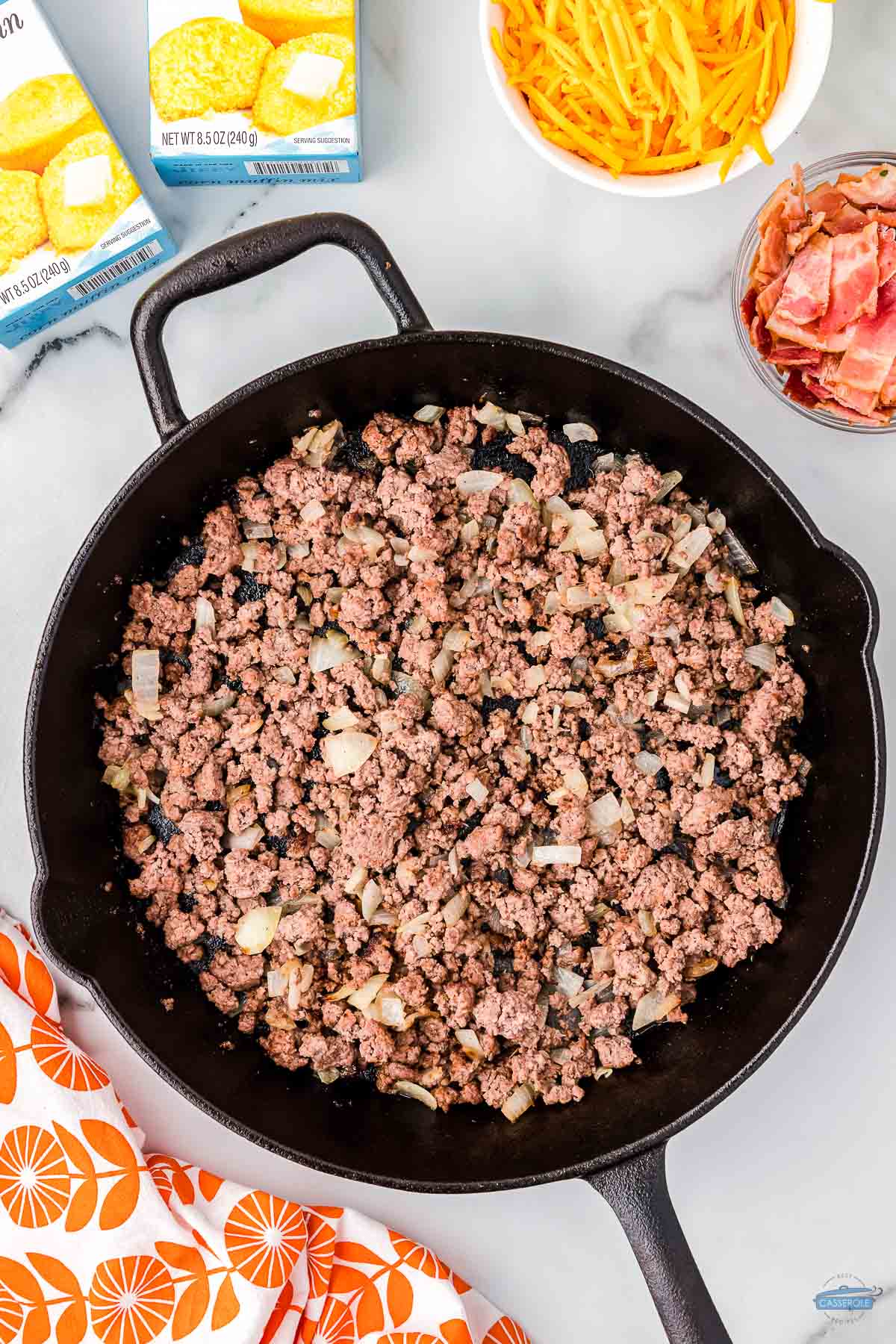 cooked ground beef and onions in a cast iron skillet
