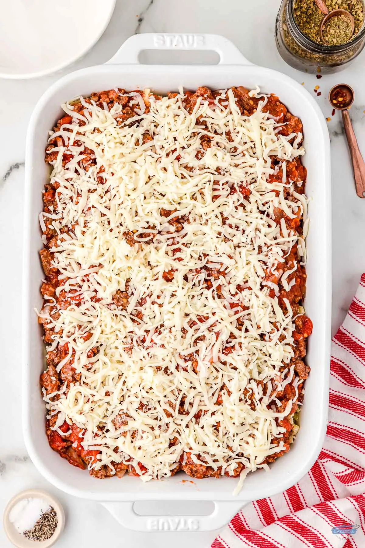 red sauce in a dish topped with shredded cheese
