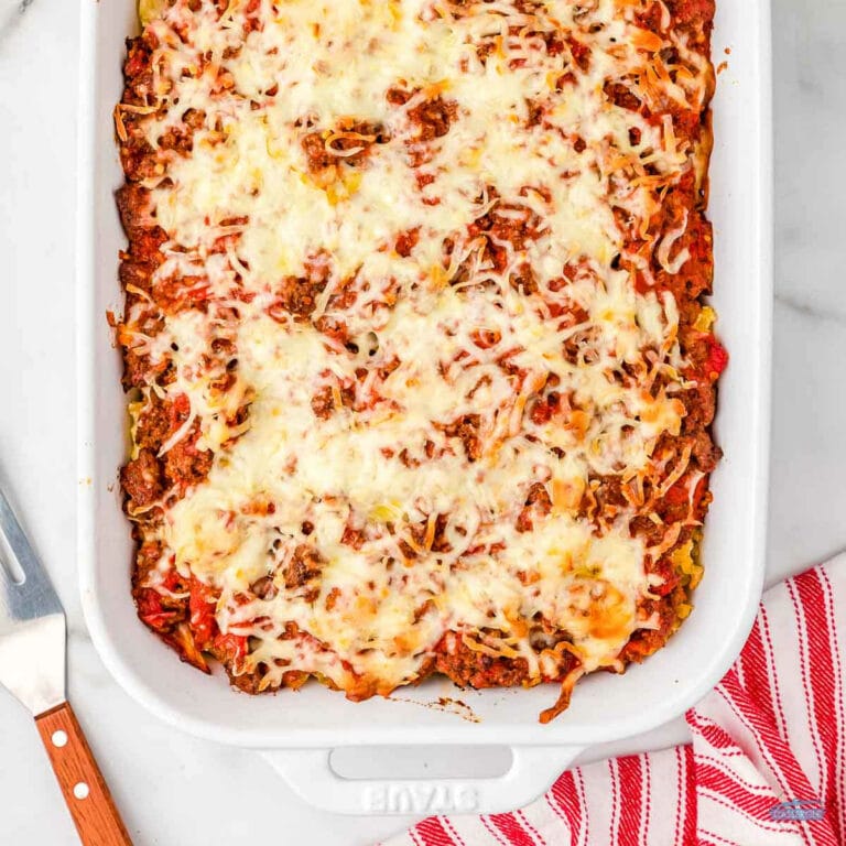 half pan of lasagna casserole in a white dish