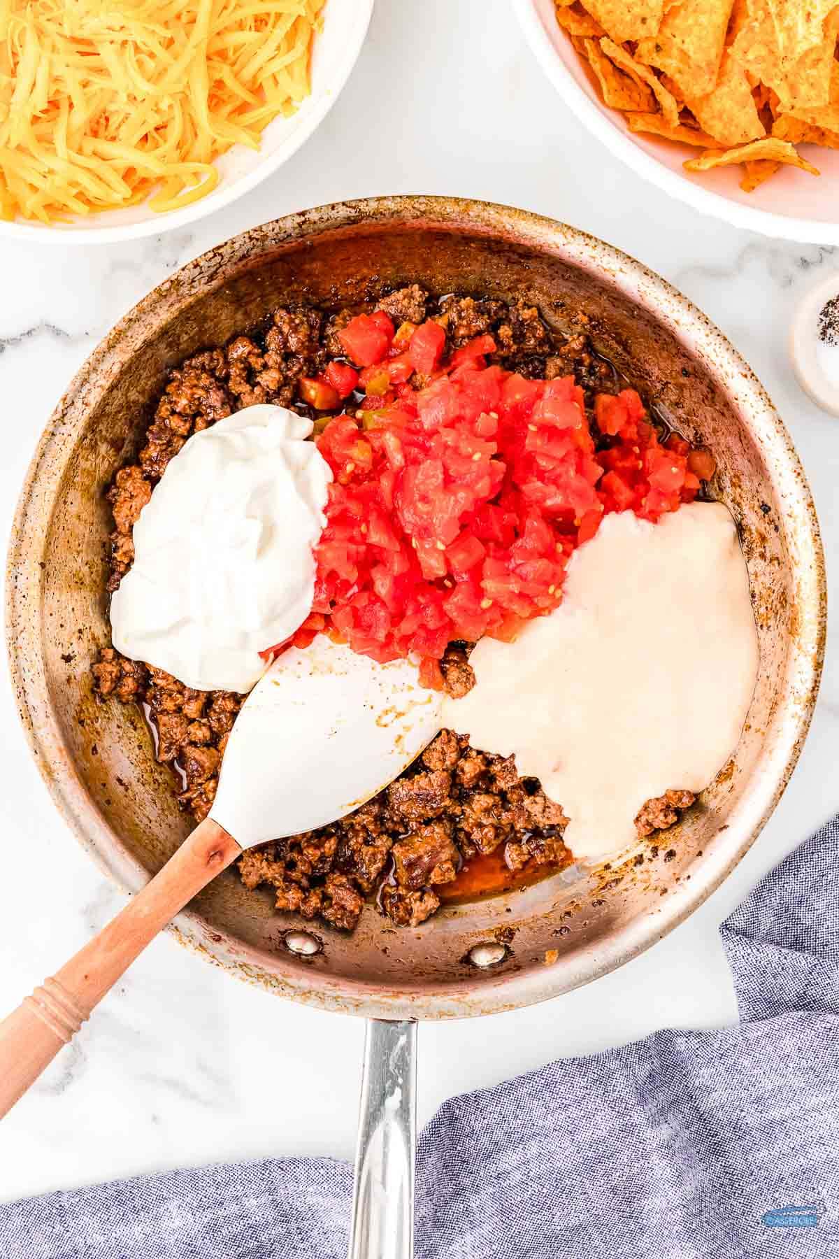 tomatoes, soup, ground beef, and cream in a skillet