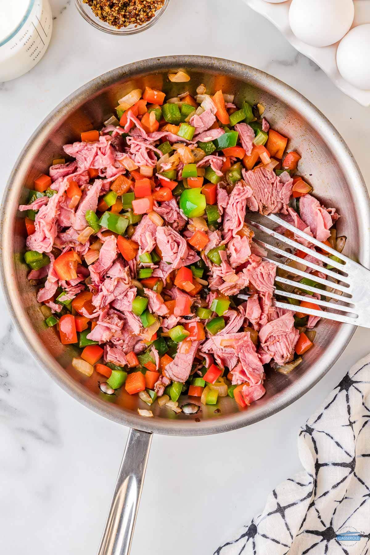 corned beef and sauteed onions and green bell pepper in a skillet
