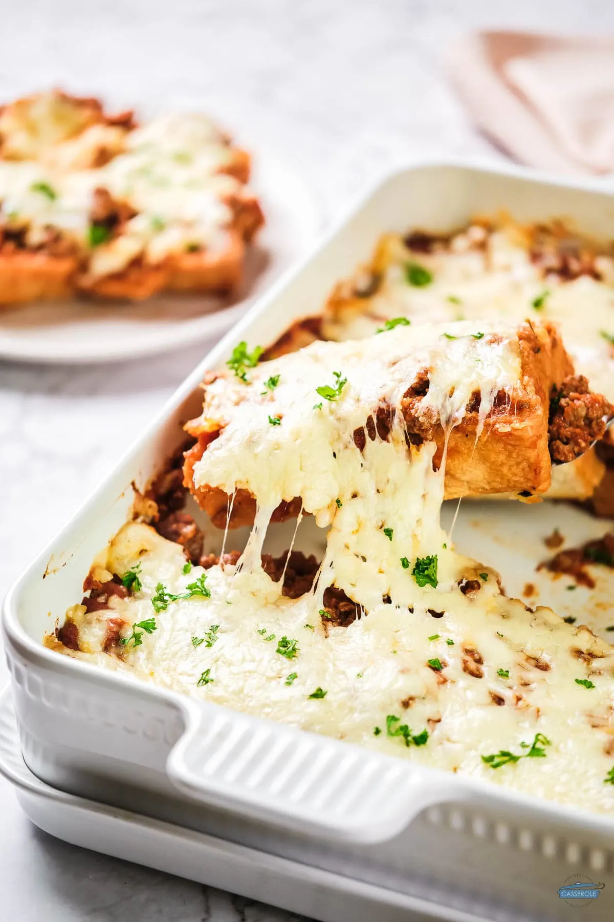 garlic bread and cheese on top in a white dish