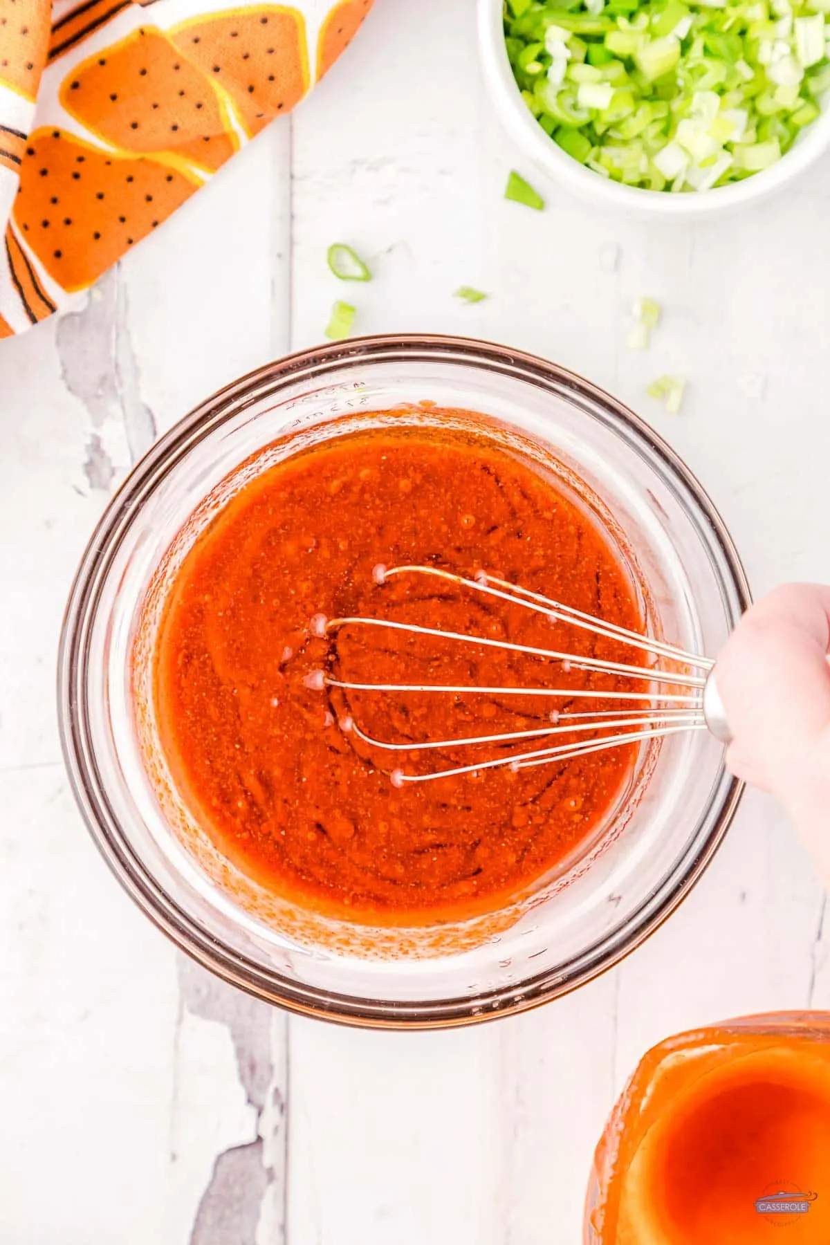 hot sauce mixture in a bowl with a whisk