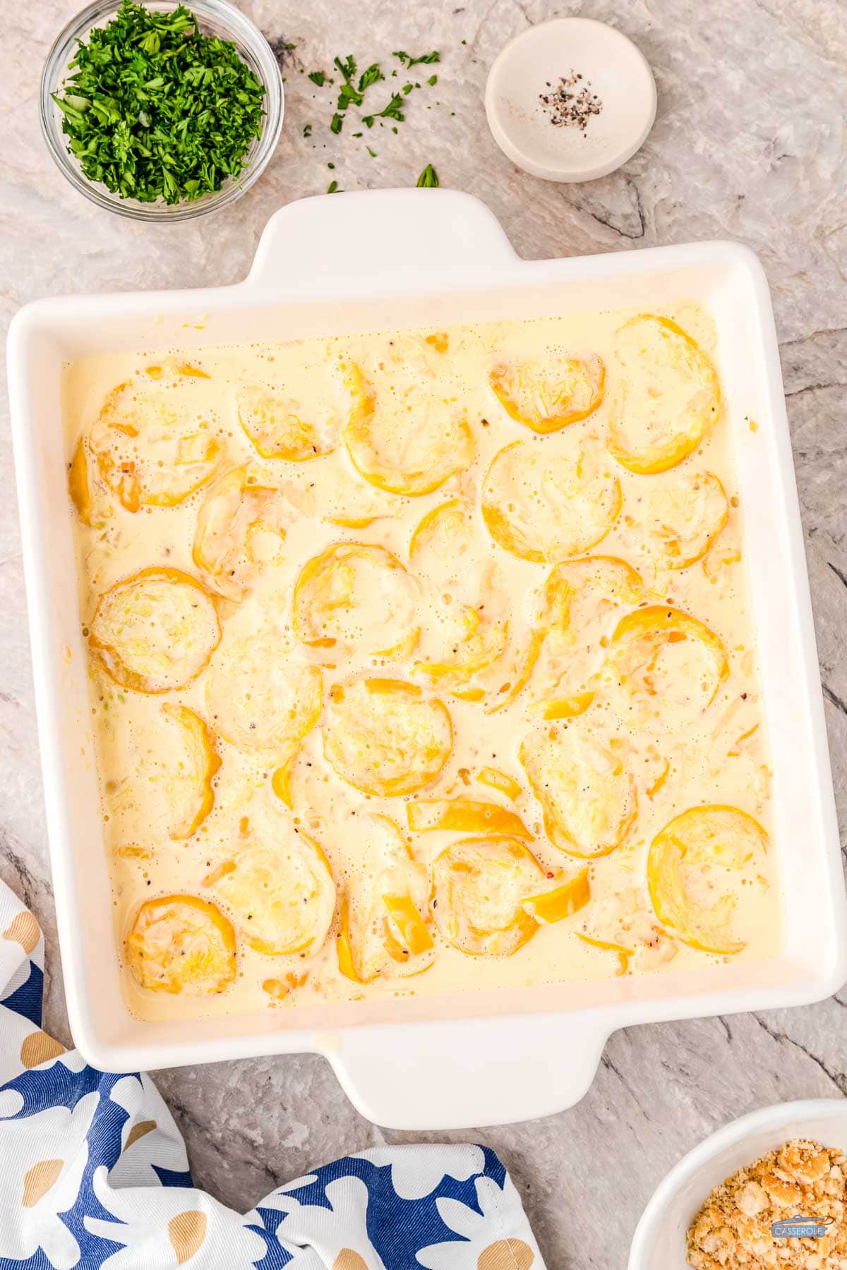 unbaked squash casserole in a square dish