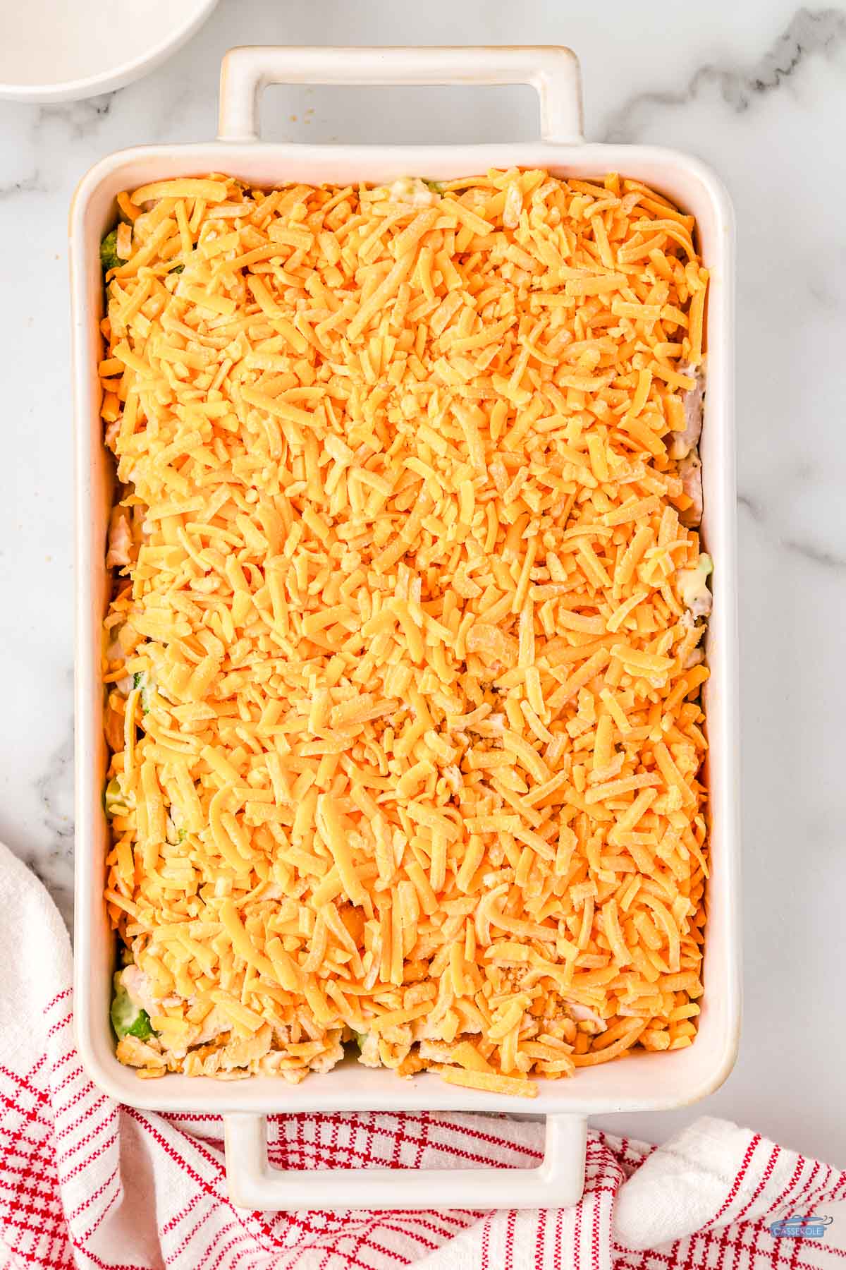 shredded cheese on top of a casserole dish