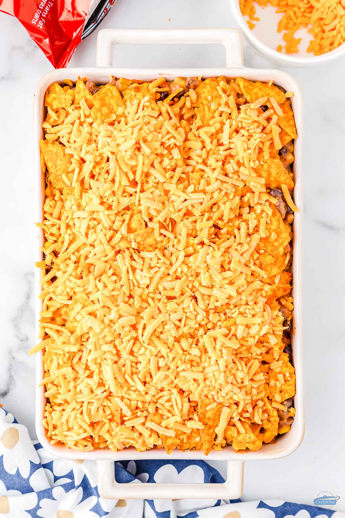 cheese on top of a casserole with a final layer of doritos for crunch