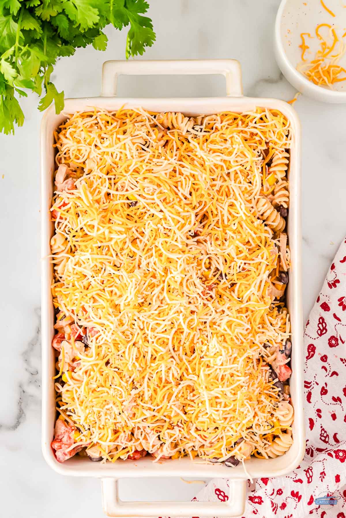 cheese on top of a casserole in a white dish