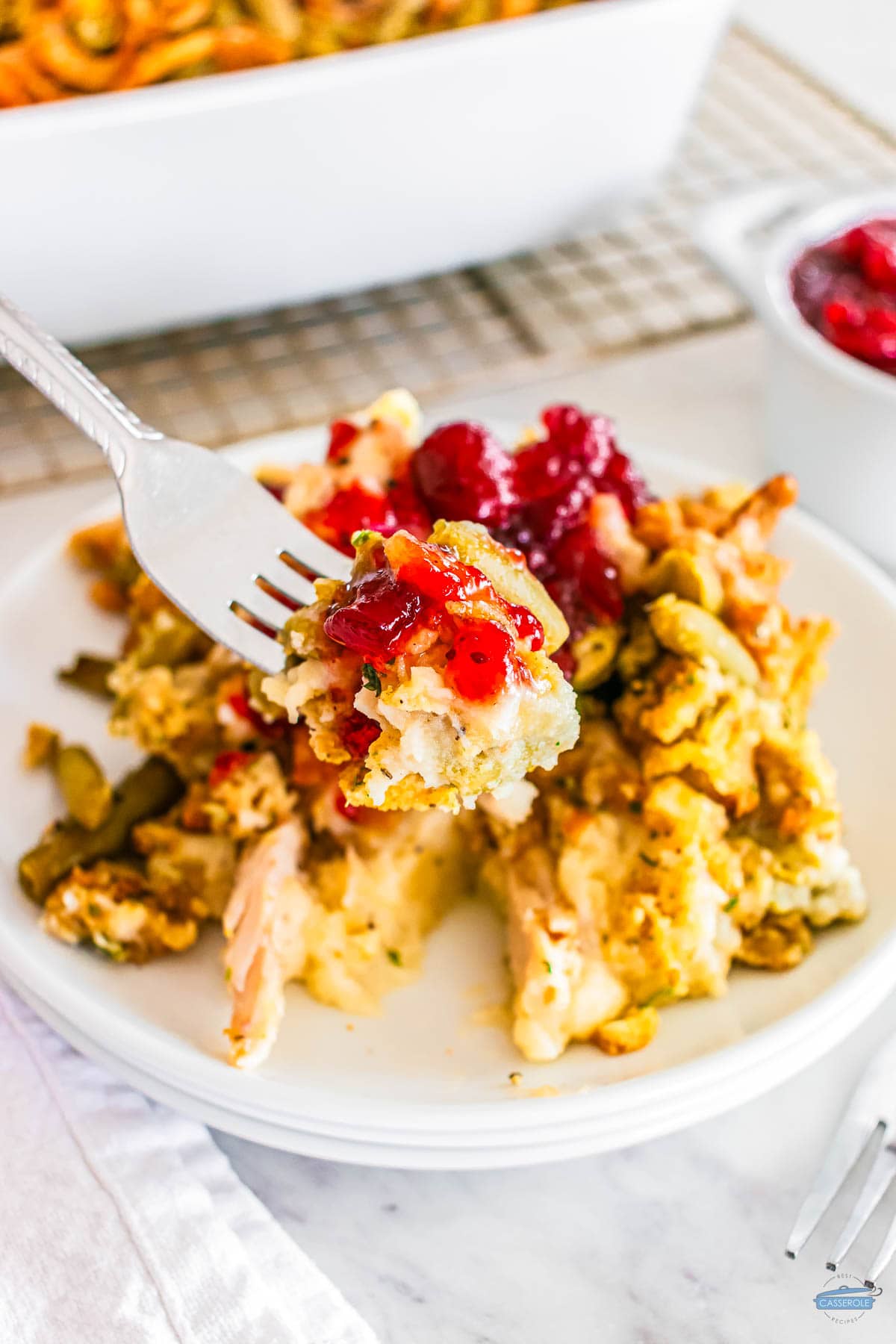 fork with bite of casserole with cranberry sauce