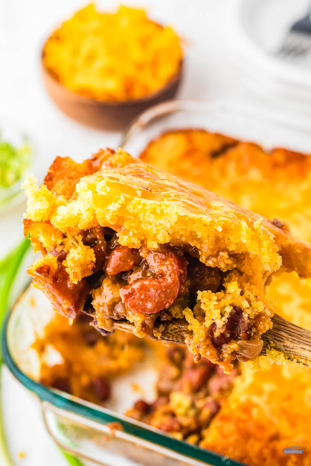 scoop of hot dog casserole on a wood spoon